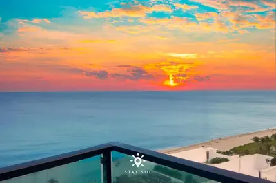 a sunset over the beach and the ocean at Luxury by the Sea- 2BR Pool & Gym -Hollywood in Hollywood