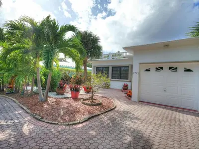 a house with a white garage and palm trees at Holiday Home Guest House at the Ocean by Interhome in Fort Lauderdale