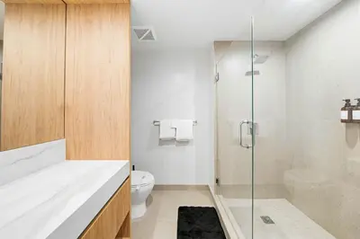 a bathroom with a toilet and a glass shower at Miami Highline- Sauna Heated Pool Cabanas in Miami