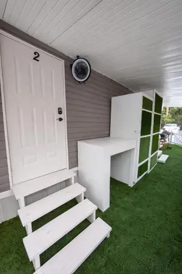 a porch with stairs and a door and a clock at PrimeStay Modern Studio in Prime Location in Hollywood