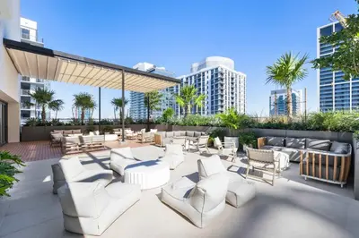 a patio with white chairs and tables and buildings at Modern Condo in Downtown Miami Near Bayside in Miami
