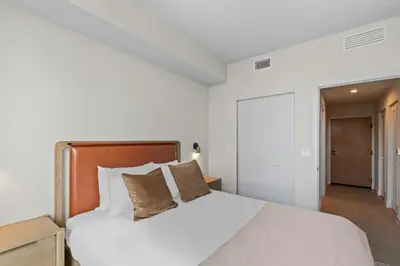 a bedroom with a bed with white sheets and pillows at Downtown Stay with Rooftop Pool Amenities in Miami