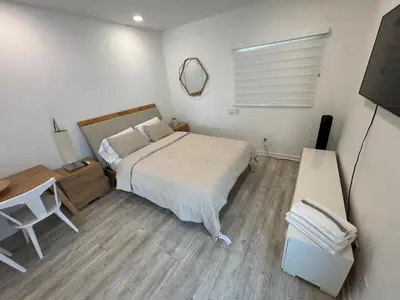 a bedroom with a bed and a desk and a television at Central location in Cutler Bay
