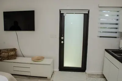 a kitchen with a sliding glass door and a tv at Central location in Cutler Bay