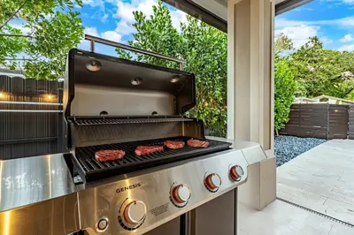 a grill with hamburgers on it on a patio at Casa Monstera Heated Saltwater Pool Game Room Golf in Fort Lauderdale