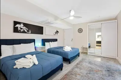 a bedroom with two blue beds and a window at Private Oasis with Heated Saltwater Pool Tropical Backyard in Dania Beach