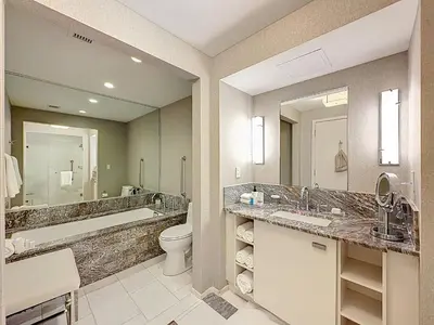a bathroom with two sinks and a toilet and a mirror at Fort Lauderdale Beach Luxury - Ocean View Condo in Fort Lauderdale