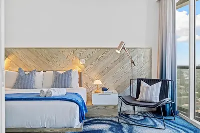 a bedroom with a king sized bed and a chair at W Fort Lauderdale Corner Unit with Ocean View and Resort Access - 2BR 2BA in Fort Lauderdale