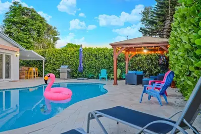 a swimming pool with a pink flamingo in a backyard at 4 Bedroom Villa Pool Game Room By Beach & Hard Rock in Pembroke Pines