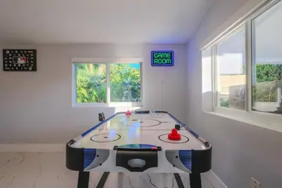 a ping pong table in a room with a sign at 4 Bedroom Villa Pool Game Room By Beach & Hard Rock in Pembroke Pines