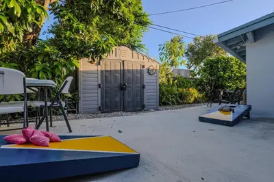 a backyard with a yellow and blue mat and chairs at 4 Bedroom Villa Pool Game Room By Beach & Hard Rock in Pembroke Pines