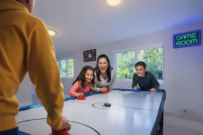 a group of people sitting around a table at 4 Bedroom Villa Pool Game Room By Beach & Hard Rock in Pembroke Pines
