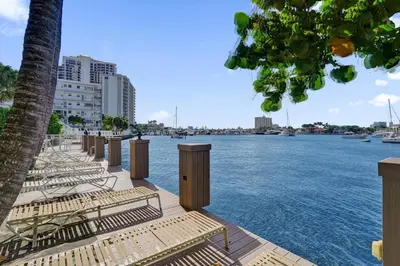 a row of benches sitting next to the water at Fort Lauderdale Waterfront Condo! Pool and Marina Views in Fort Lauderdale