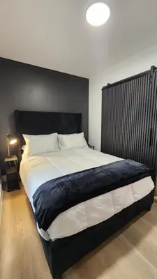a large bed with a black headboard in a bedroom at Pop Art Loft in Hialeah