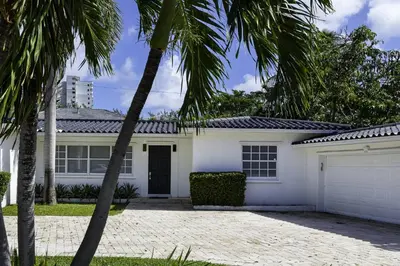 a white house with palm trees in front of it at Harbor Beach in Fort Lauderdale