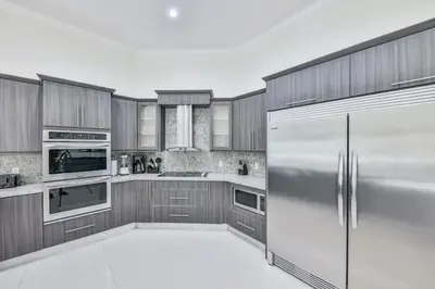 a kitchen with wooden cabinets and a stainless steel refrigerator at Supremacy Villa STR-6110 in Davie
