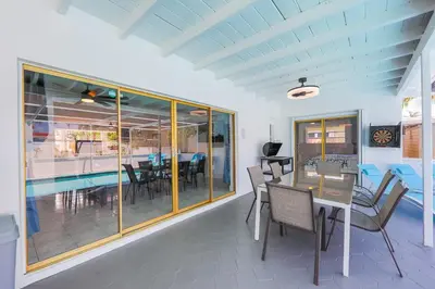 a dining room with a table and chairs and a pool at Eat Pray Love Villa in Hollywood