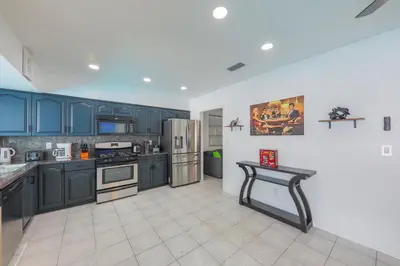 a kitchen with blue cabinets and a table in it at Eat Pray Love Villa in Hollywood
