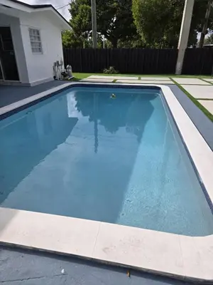 a swimming pool with blue water in a yard at Sunrise Oasis in Sunrise