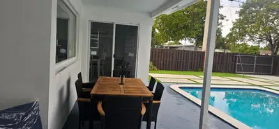 a table and chairs on a patio next to a pool at Sunrise Oasis in Sunrise