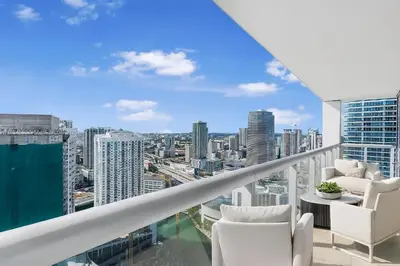 a balcony with white chairs and a view of a city at Icon Brickell Penthouse Panoramic Skyline by IliosRentals in Miami