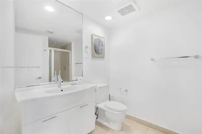 a white bathroom with a toilet and a sink at Icon Brickell Penthouse Panoramic Skyline by IliosRentals in Miami