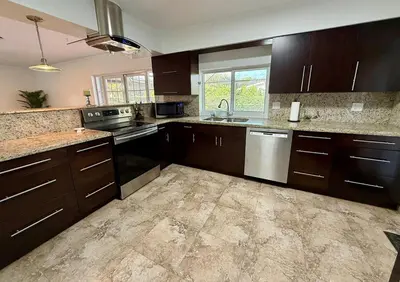 a large kitchen with brown cabinets and a sink at House across from Baptist Hospital in Sunset Corners
