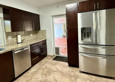 a kitchen with wooden cabinets and stainless steel appliances at House across from Baptist Hospital in Sunset Corners