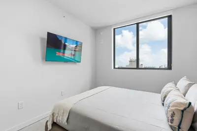 a white bedroom with a bed and a window at Premium High-Rise Living at 501 First - Downtown Miami in Miami