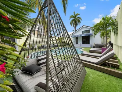 a hammock in the backyard of a house at The Gilded Palm - Near Design District - Pool & Hot Tub in Miami