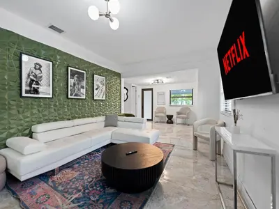 a living room with a white couch and a table at The Gilded Palm - Near Design District - Pool & Hot Tub in Miami