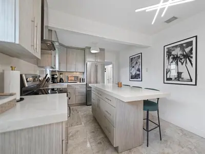 a kitchen with white counters and a island in it at The Gilded Palm - Near Design District - Pool & Hot Tub in Miami