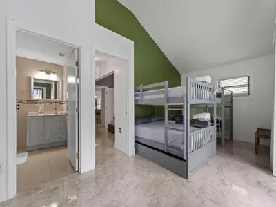 a bedroom with a bunk bed and a bathroom at The Gilded Palm - Near Design District - Pool & Hot Tub in Miami