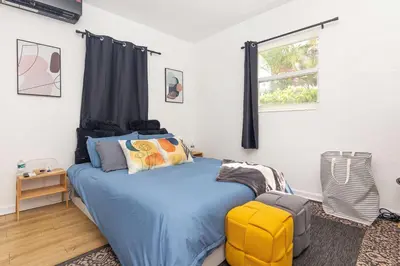 a bedroom with a blue bed and a window at Serene Cottage Retreat Ideal for Couples & Solo Travelers in Miami