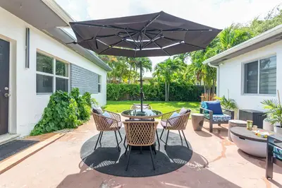 a patio with a table and chairs and an umbrella at Serene Cottage Retreat Ideal for Couples & Solo Travelers in Miami