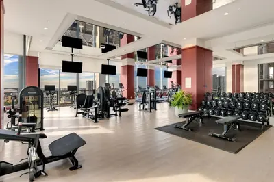 a gym with rows of exercise equipment in a building at Crosby Miami WTC 2BR 2BA Corner City Residence #601 in Miami