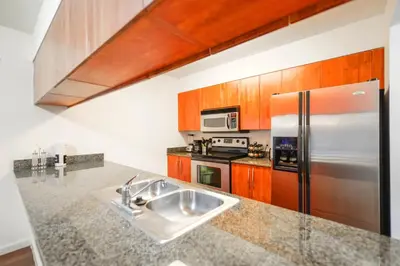 a kitchen with a sink and a refrigerator at Brickell Stay with City Views in Miami