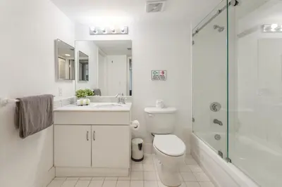 a white bathroom with a toilet and a shower at Brickell Stay with City Views in Miami