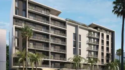 an apartment building with palm trees in front of it at Sleeps 18 3 Suites in New Luxury Hotel w Rooftop Pool Sense28 by AvantStay in Miami