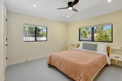a bedroom with a bed and two windows at Hollywood Palms: Mins to beach, Pool, Spa, BBQ in Hollywood