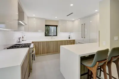 a kitchen with white cabinets and a counter top at Hollywood Palms: Mins to beach, Pool, Spa, BBQ in Hollywood