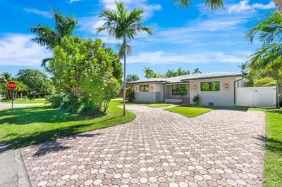 a house with palm trees in front of a driveway at Hollywood Palms: Mins to beach, Pool, Spa, BBQ in Hollywood
