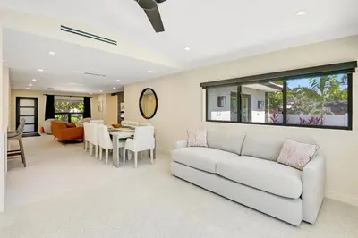 a living room with a couch and a dining room at Hollywood Palms: Mins to beach, Pool, Spa, BBQ in Hollywood