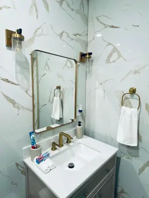 a bathroom with a sink and a mirror at The Luxe Studio in Miami Gardens