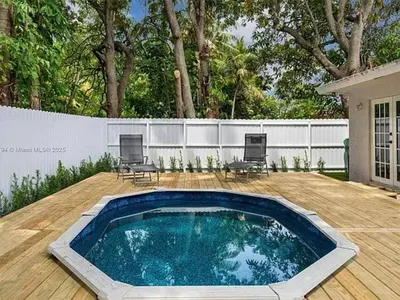 a swimming pool on a wooden deck with a fence at Large 4 bedroom Midtown Great Area in Miami