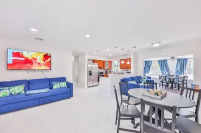 a living room with a blue couch and a table at Chill Zona Arizona Villa Perfect Cruise Stay in Fort Lauderdale