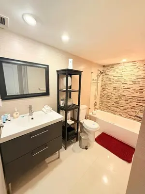 a bathroom with a sink and a toilet and a tub at Modern 2BR beachfront with pool & tennis view in Sunny Isles Beach