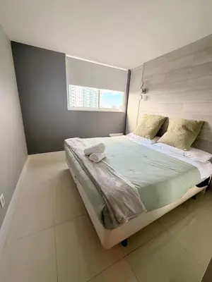 a bedroom with a large bed with a window at Modern 2BR beachfront with pool & tennis view in Sunny Isles Beach