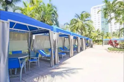a row of blue tables and chairs on the beach at Introdused by Ocean Reserve free parking STR-02559 in Sunny Isles Beach