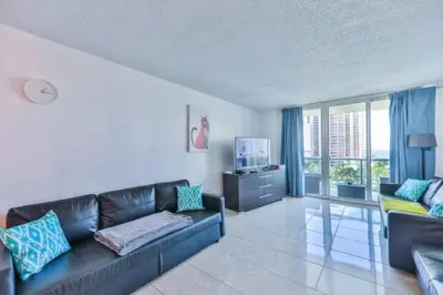 a living room with a black leather couch and a television at Introdused by Ocean Reserve free parking STR-02559 in Sunny Isles Beach